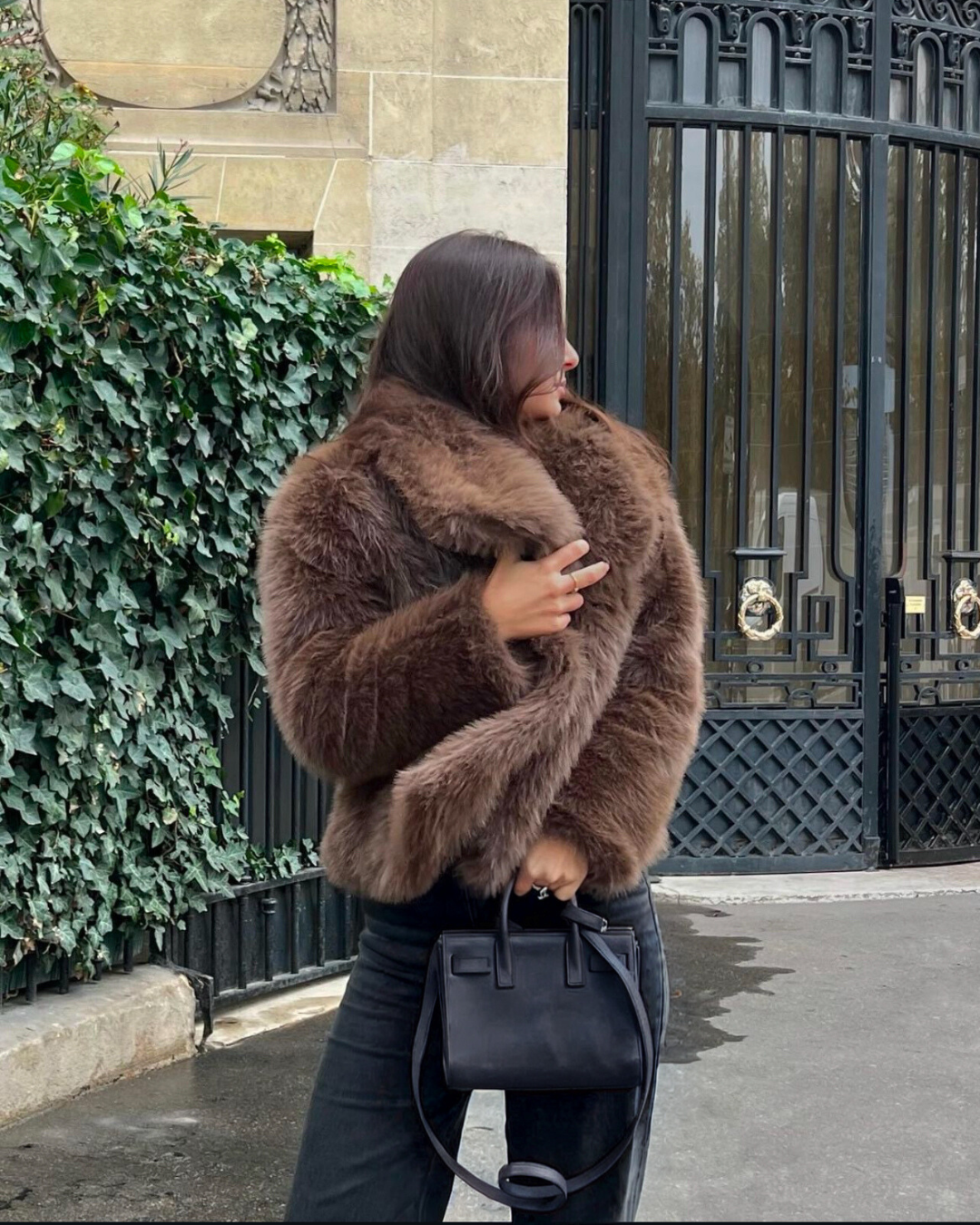 Person wearing a brown fur coat in an urban setting