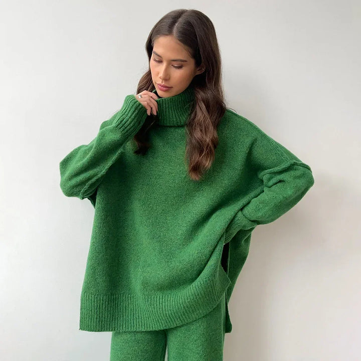Woman wearing a green sweater and pants against a white background