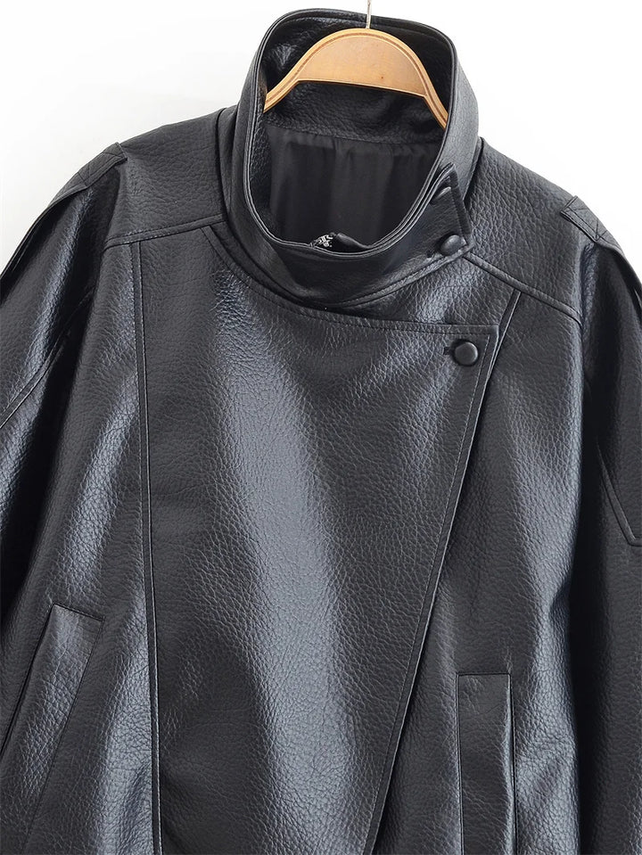 Close-up of a black leather jacket on a hanger with a white background