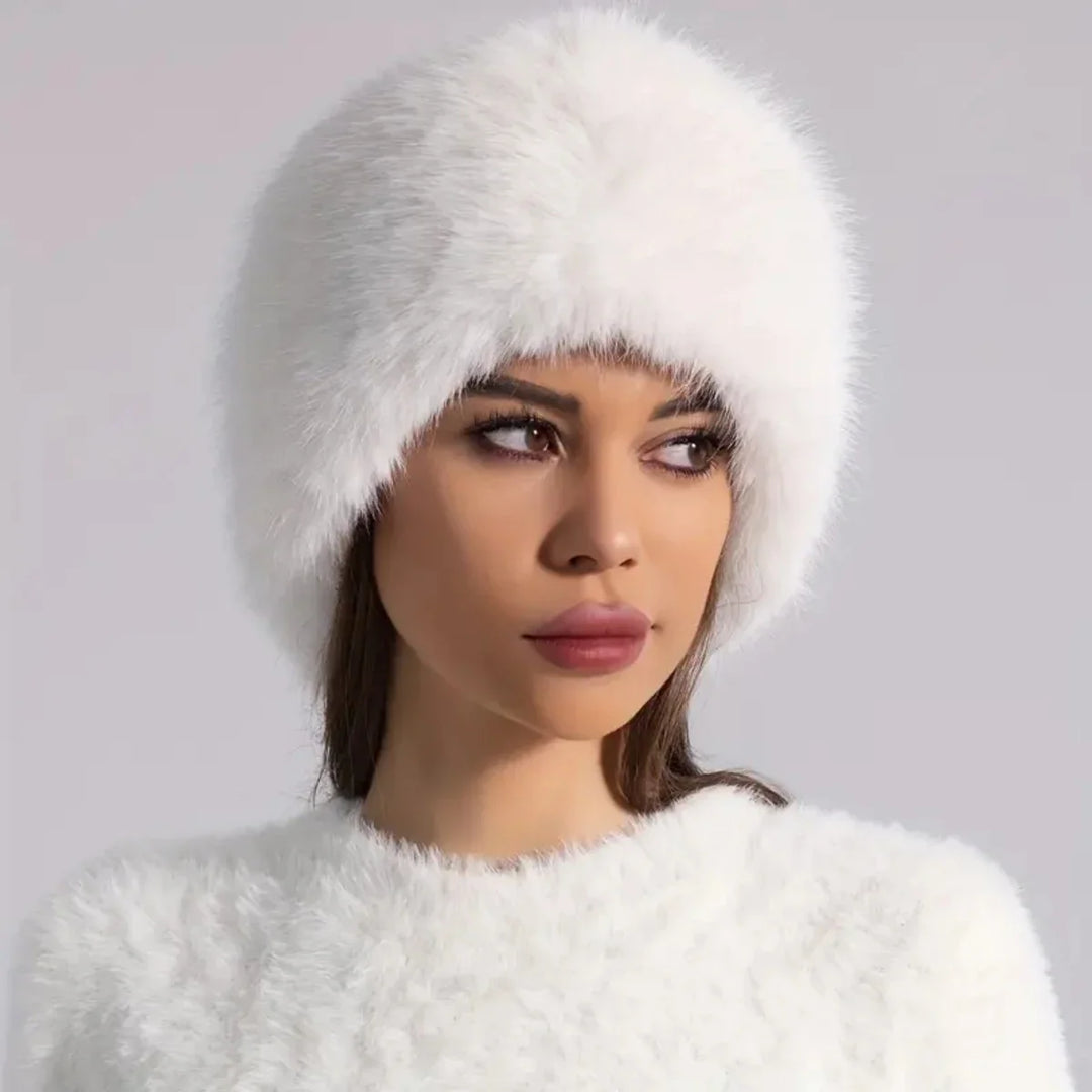 Woman wearing a white fur hat against a light gray background
