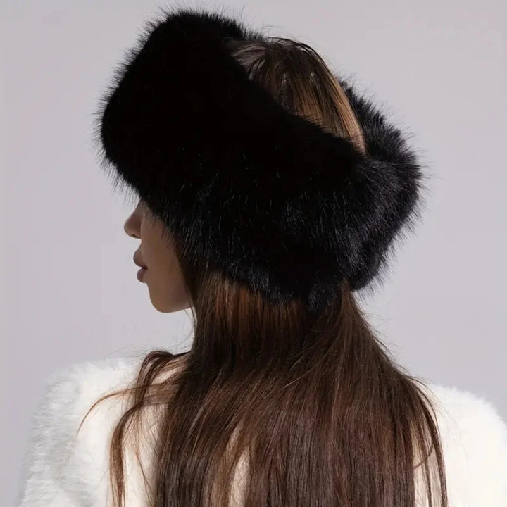 Person wearing a black fur headband against a gray background