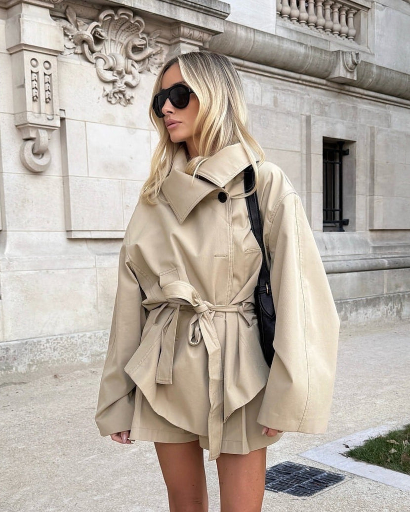 Woman wearing a beige trench coat in an urban setting